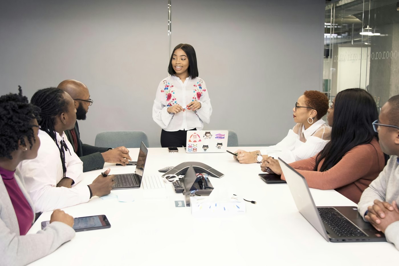 Account lead presenting a client brief to her agency team around a meeting table