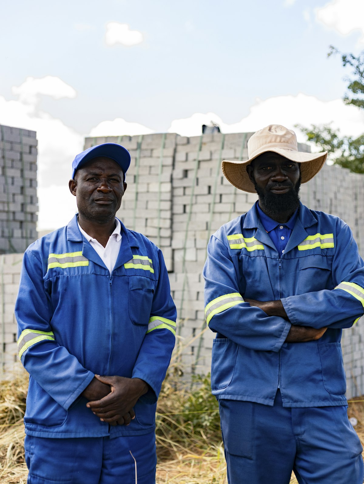 Two site workers in blue work uniforms