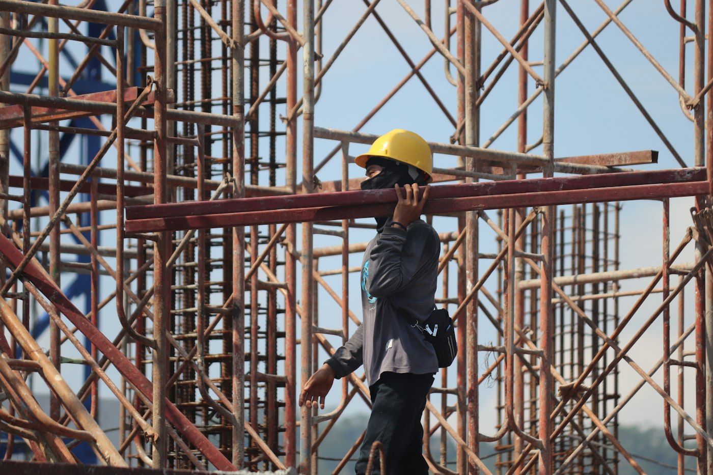 Builder in a hard hat working on scaffolding