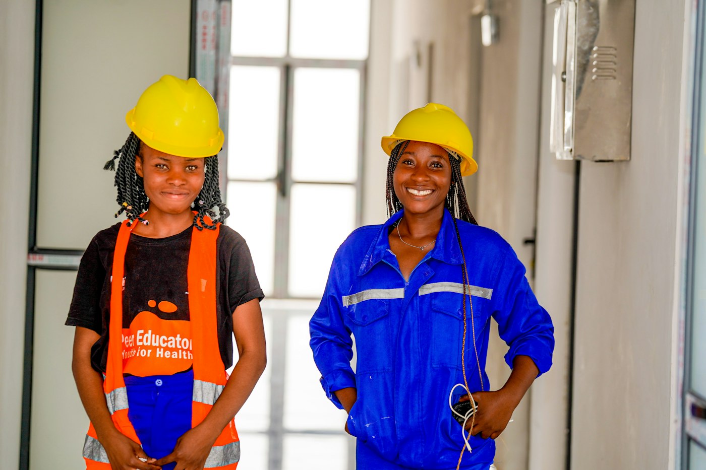 Two site engineers in hard hats smiling on site