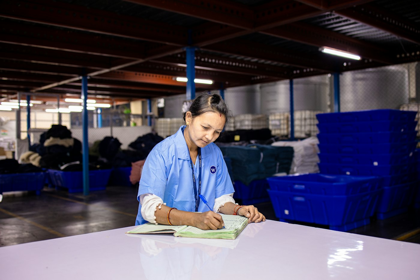 Sales administrator writing at a work table in the warehouse office