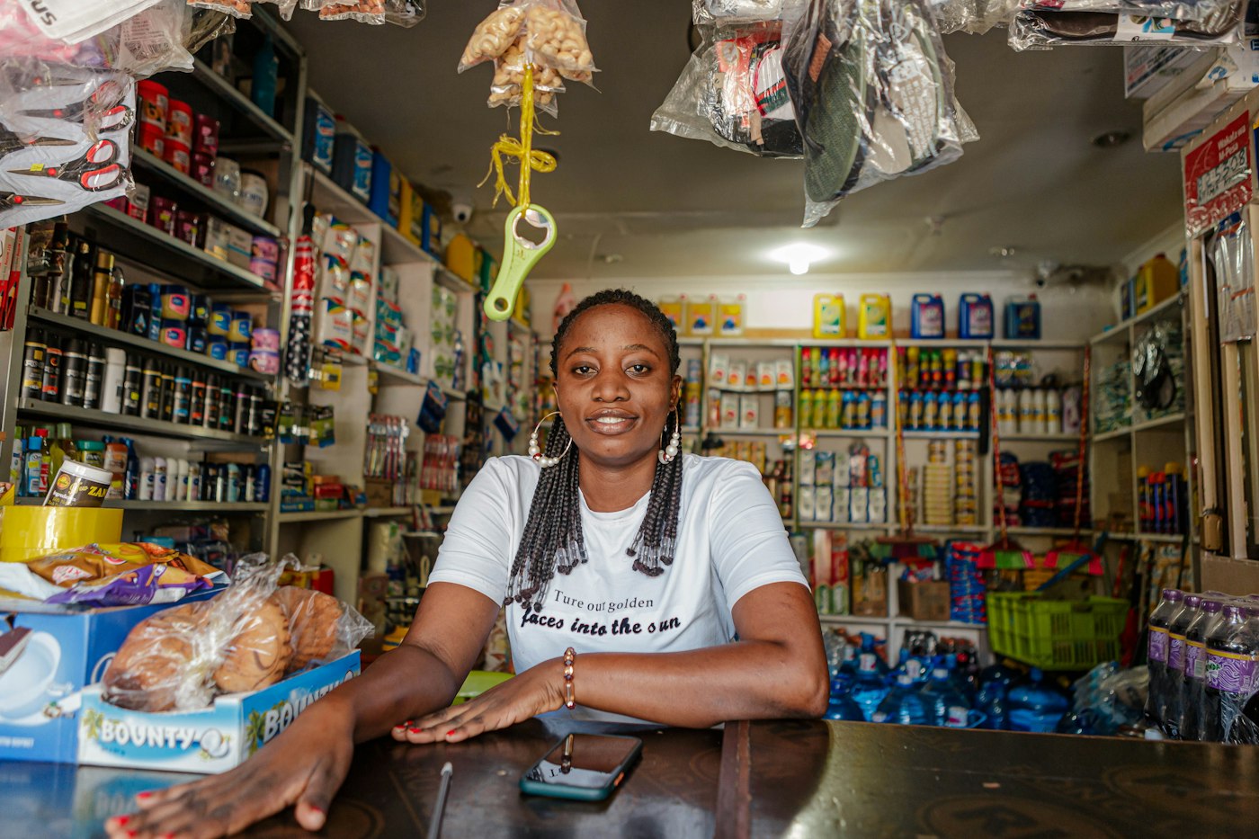Shop owner smiling at the counter of her duka