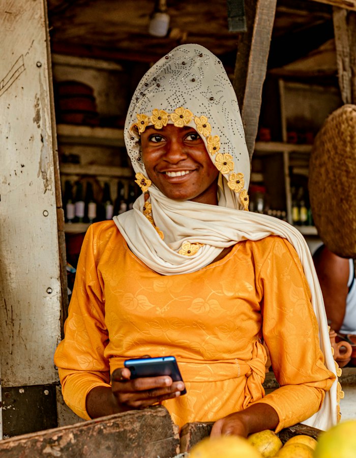 Market trader smiling as she checks a payment on her phone