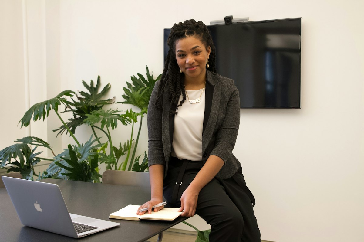 Business owner smiling as she sets up Bizflow on her laptop