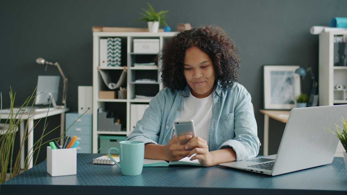 Employee checking her phone at her desk