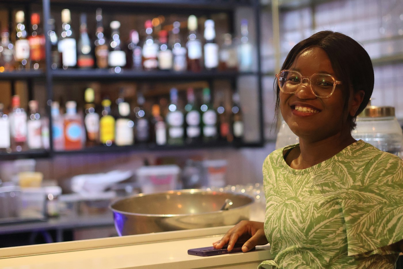 Bar and restaurant owner smiling behind her counter