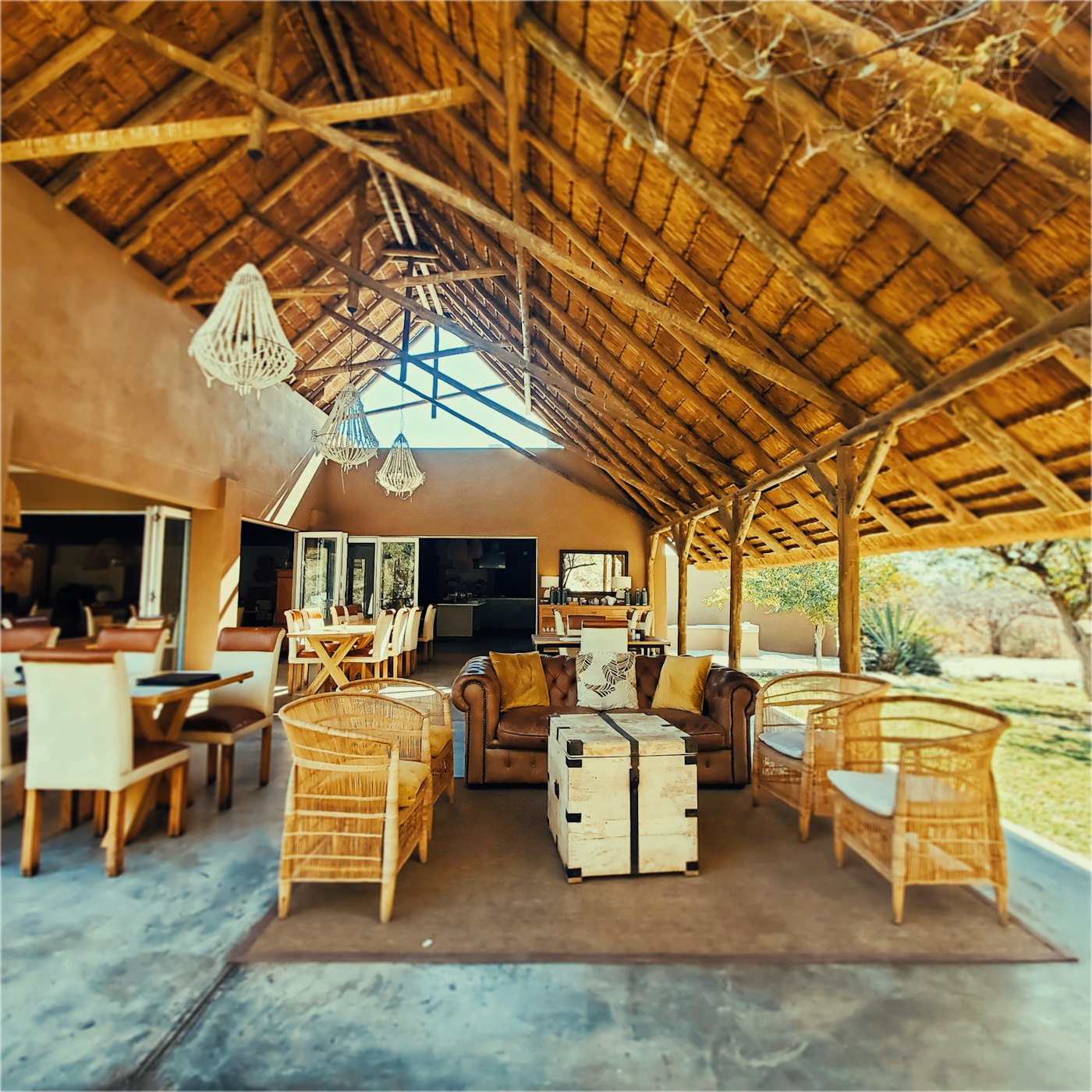 Open-air lodge lounge with a thatched roof