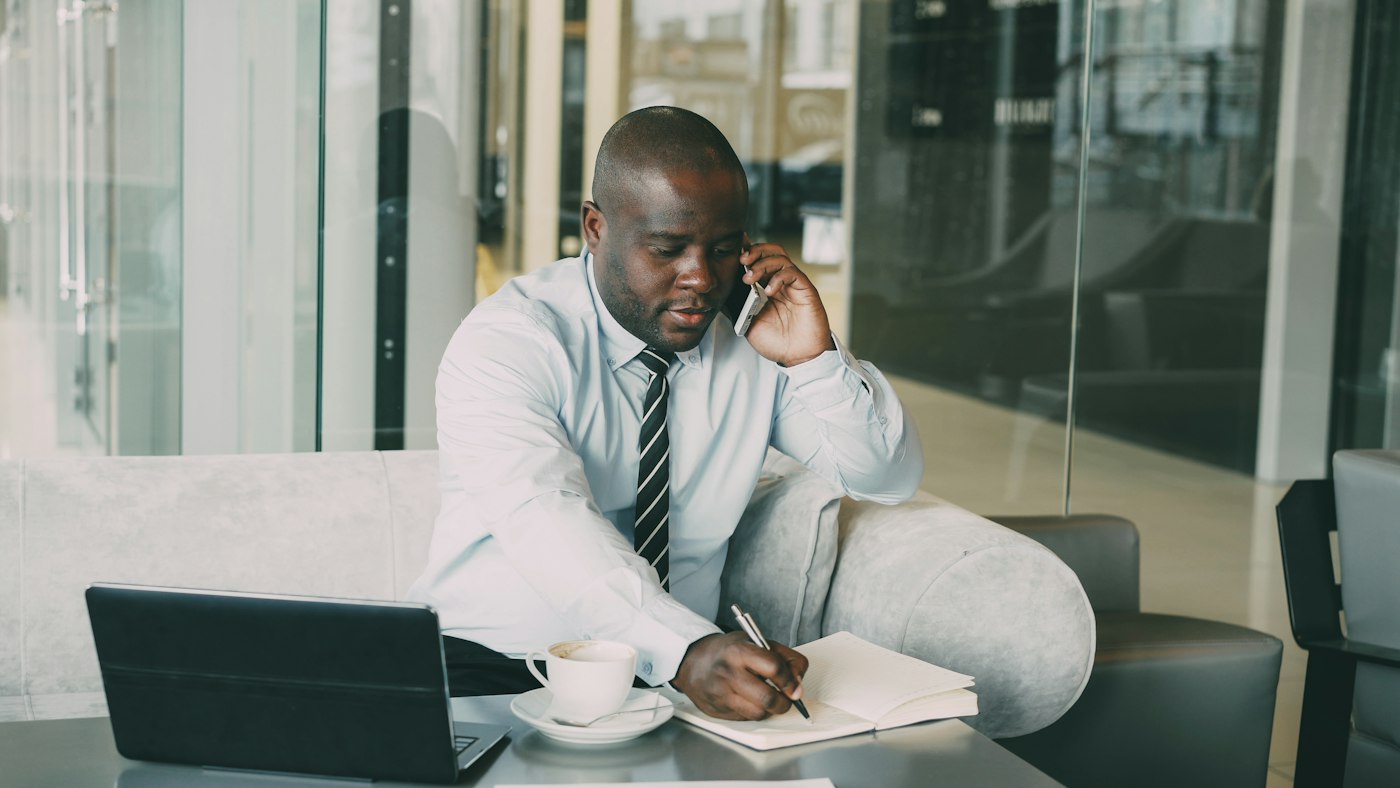 Advocate on a phone call taking notes at his desk