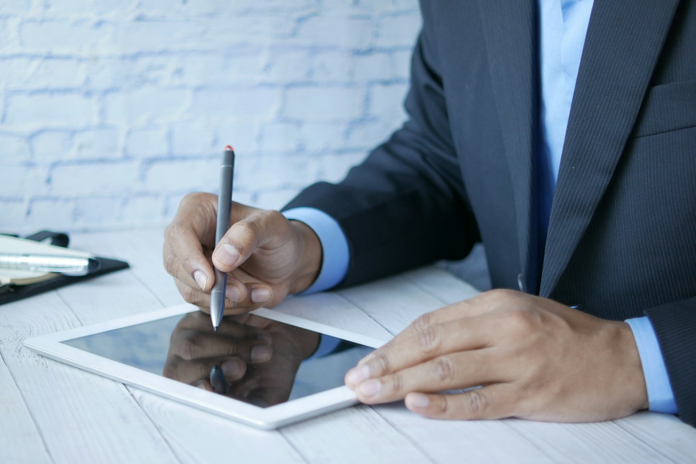 Advocate in a suit signing on a tablet