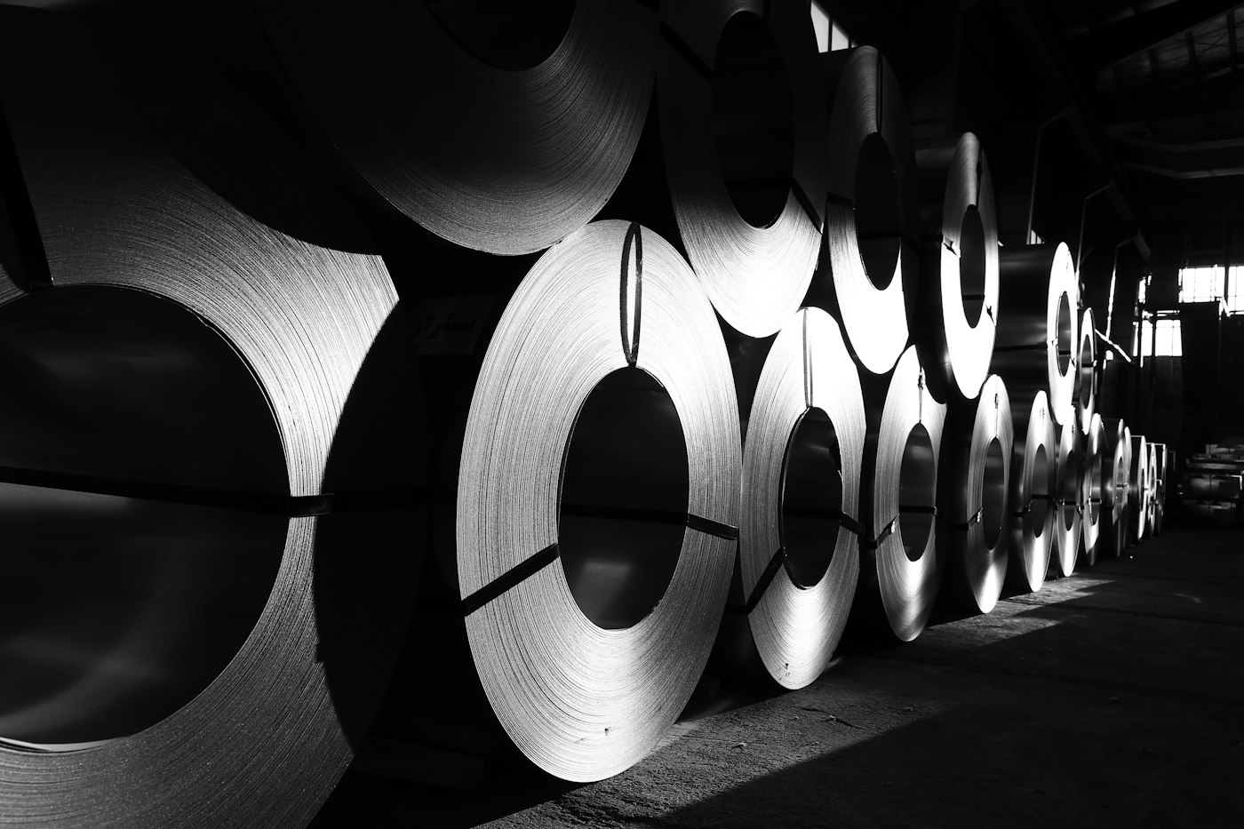 Rolls of steel coil lined up in a warehouse