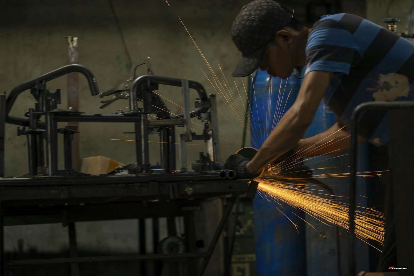 Factory worker grinding metal on the production line