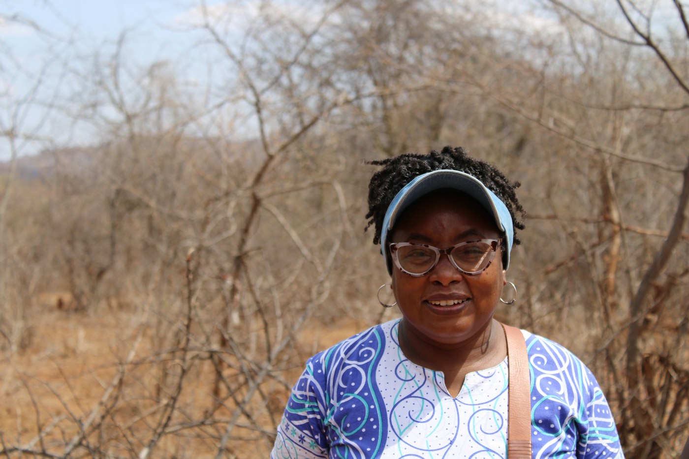 Programme officer in a visor smiling in the field