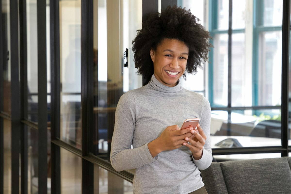 Staff member smiling as a payment arrives on her phone