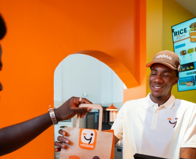 Cashier handing a customer their shopping bag