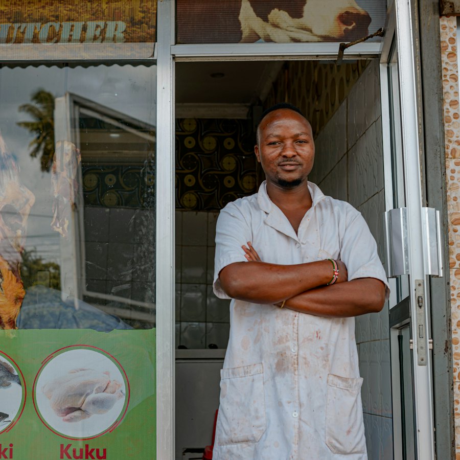 Shop owner standing with arms folded in the doorway of his shop