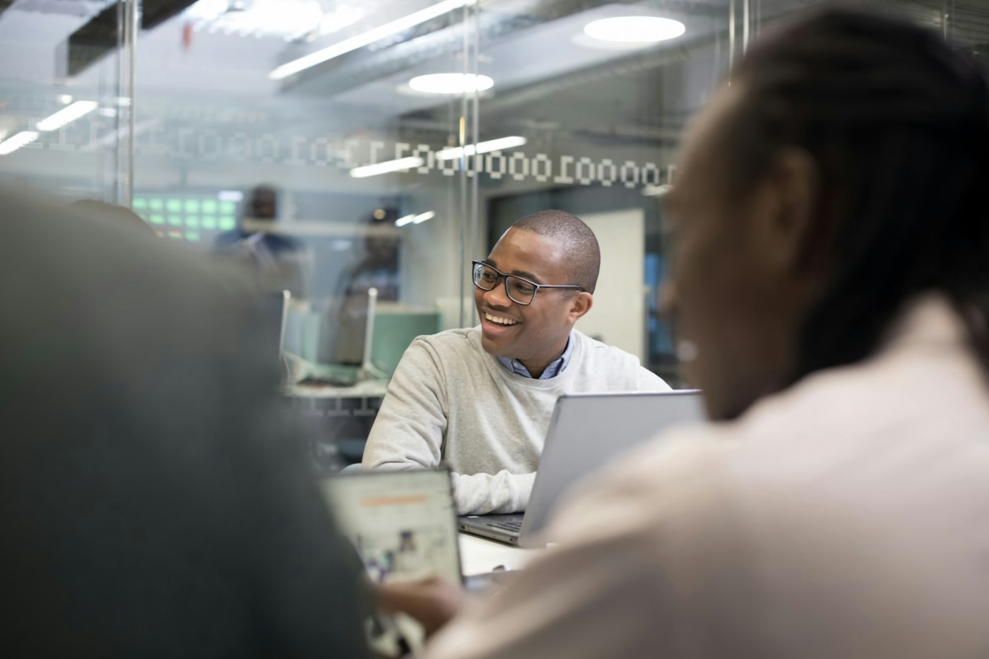 Consultant smiling in a client meeting with his laptop