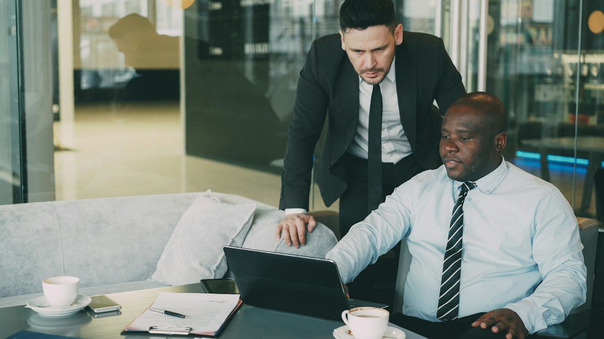 Finance manager reviewing figures with a colleague on a laptop