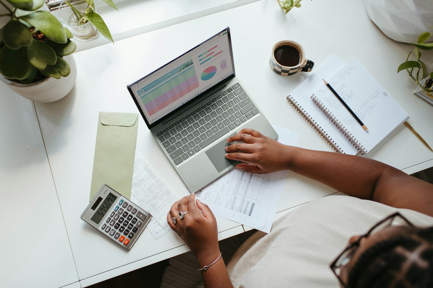 Accountant working with a laptop and calculator at her desk