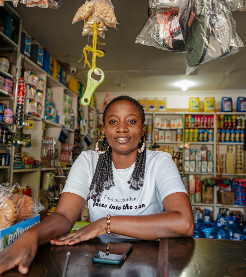 Shop owner smiling at the counter of her store