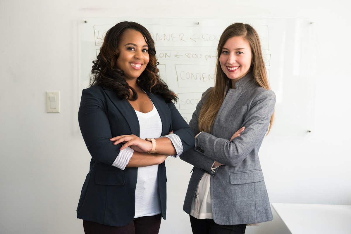 Two finance team members smiling in the office